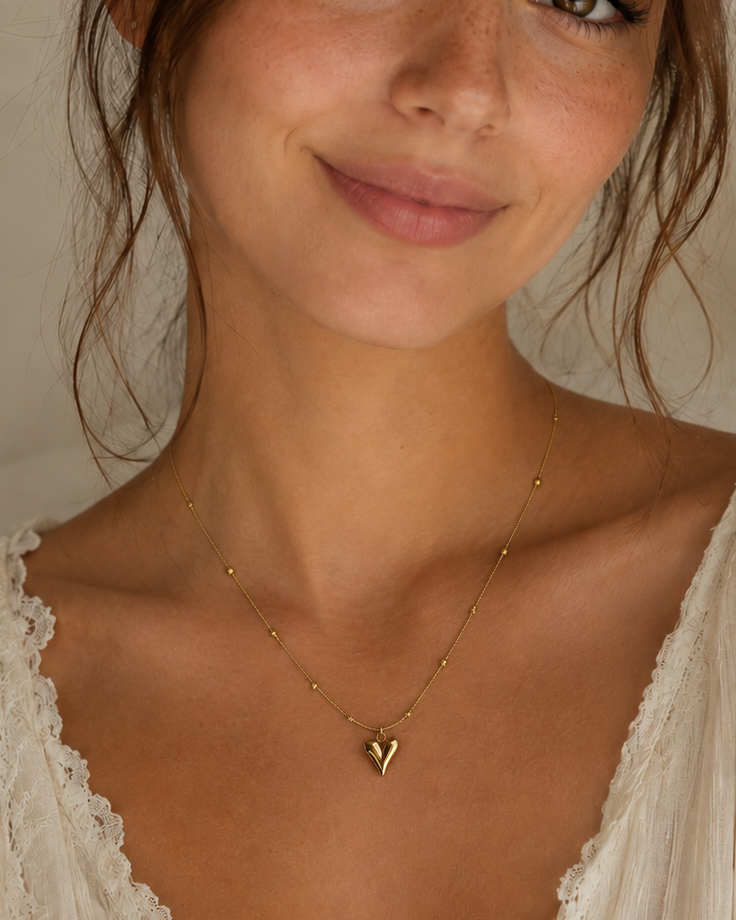 polished heart pendant on a chain with small bead accents.