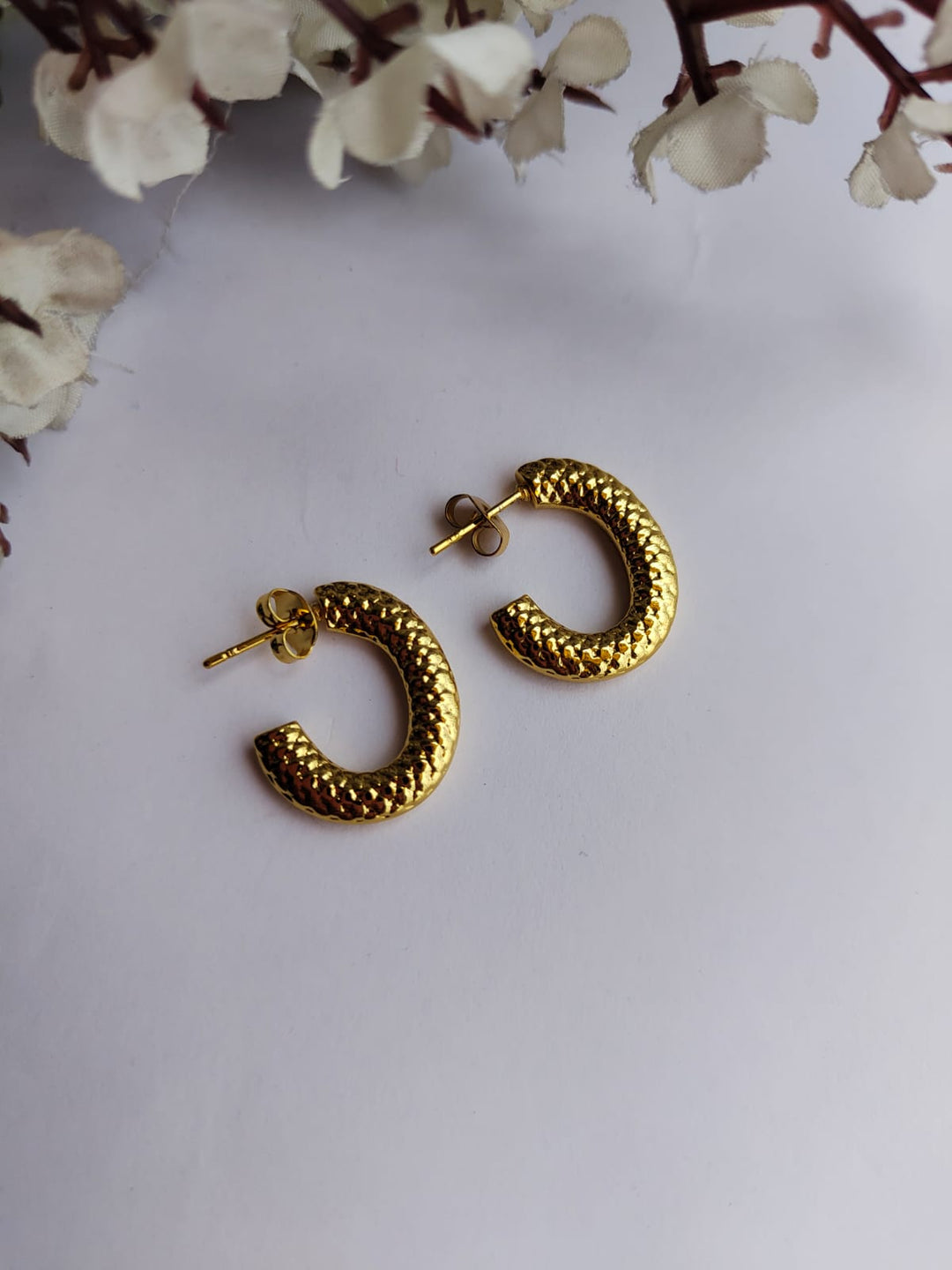 Gold-plated textured half hoop earrings with a post and back closure.